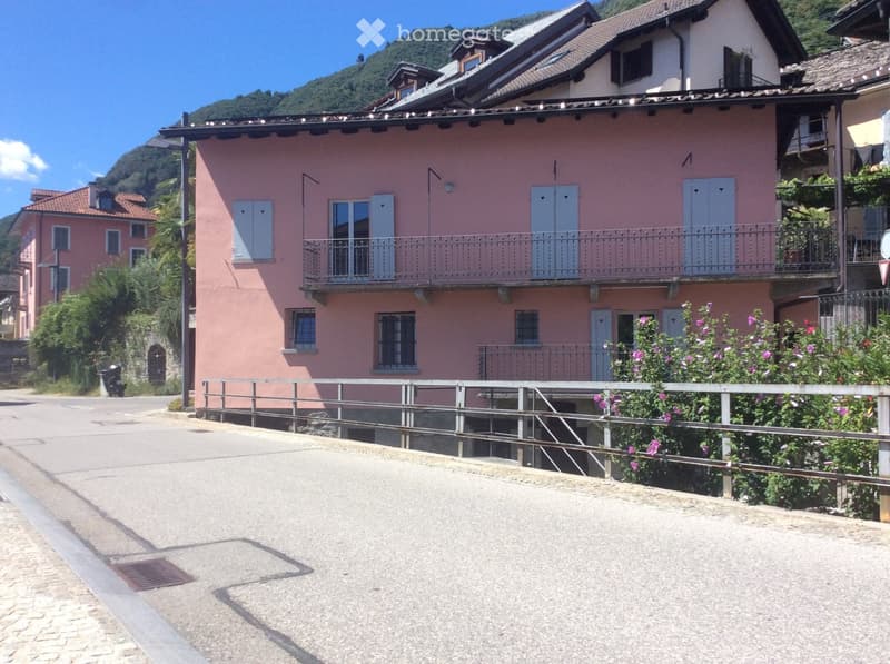 pink building, balcony with railings, windows with shutters, iron railings in front