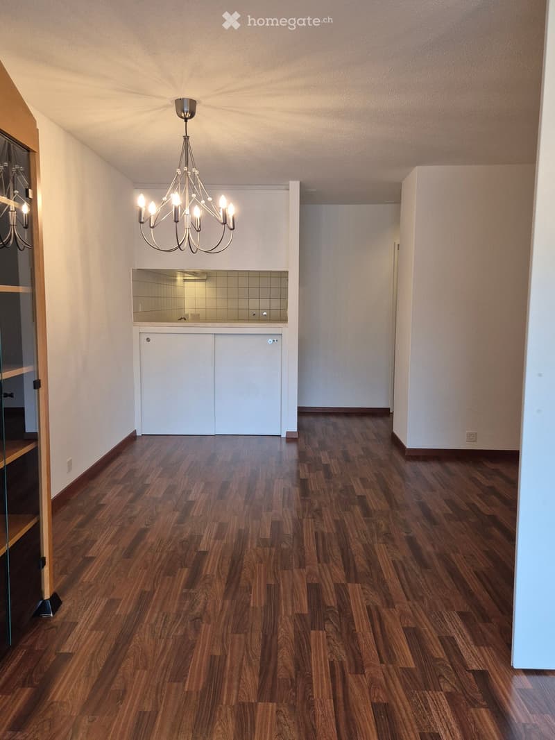 Hardwood floors, modern chandelier, white walls, kitchen with tiled backsplash, power outlets