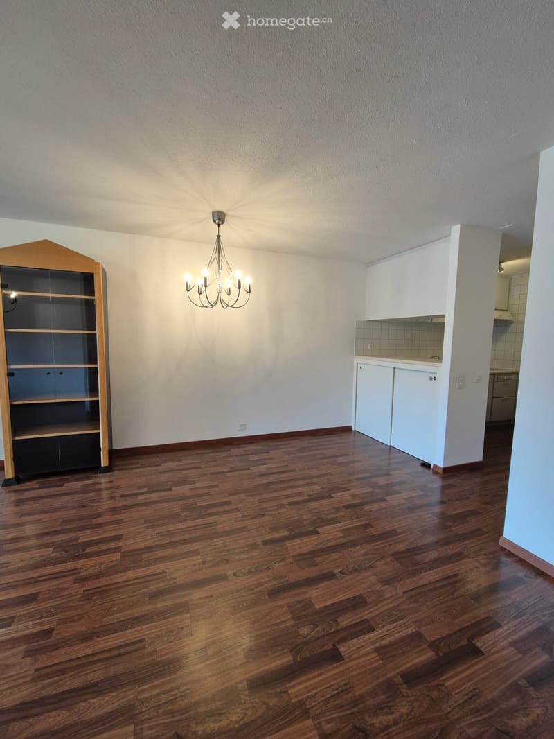 An empty room with a chandelier and a cabinet