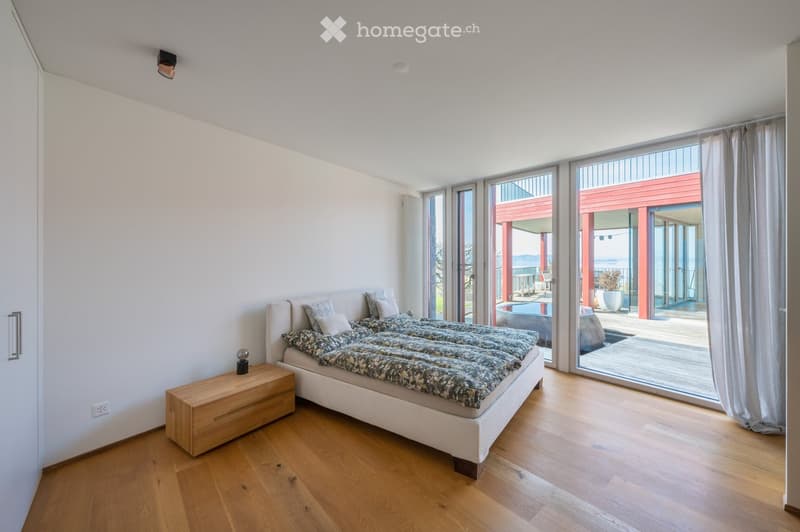bedroom with bed, nightstand, sliding glass doors, wooden floor, white walls, view of the outside
