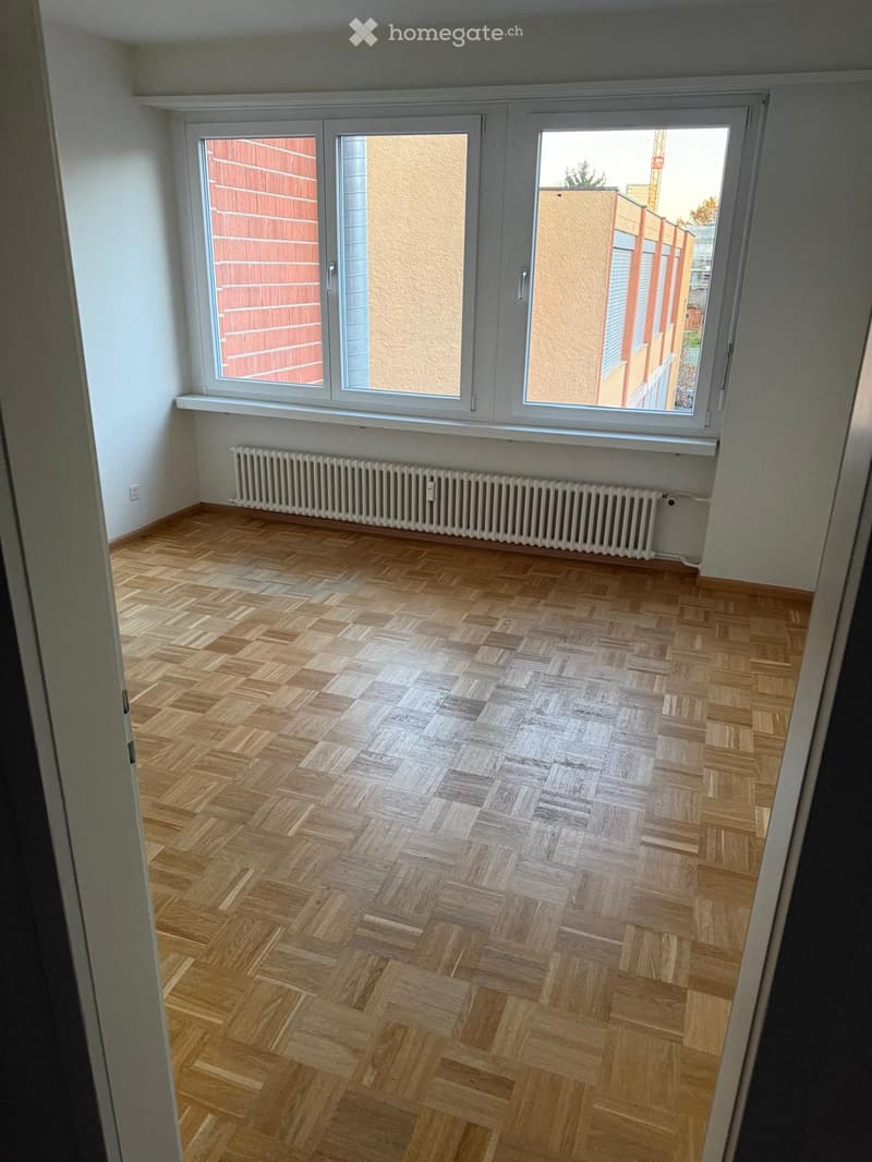 empty room, wooden parquet flooring, two windows, radiator