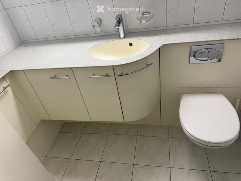 Bathroom with a sink, toilet, and white tile flooring