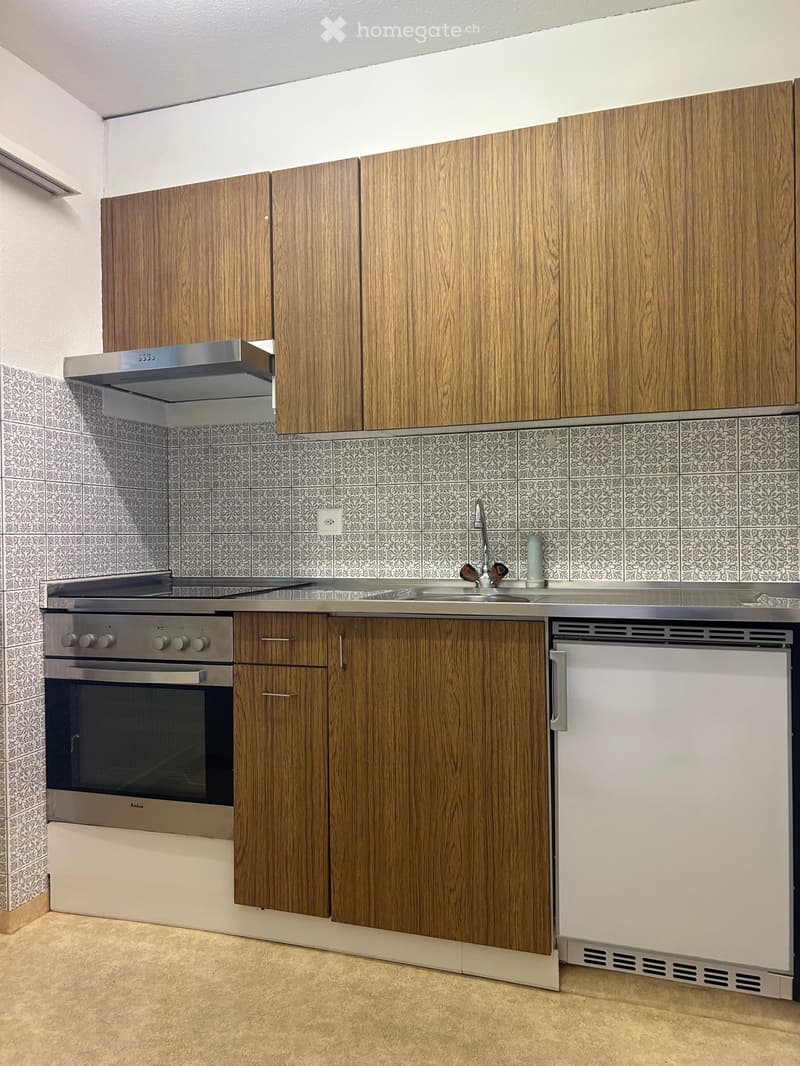 Modern kitchen with wooden cabinets, stainless steel oven, dishwasher, and sink.