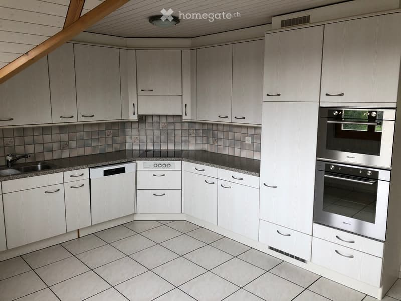 Modern kitchen with white cabinets, stainless steel appliances, tiled backsplash, and granite countertop.