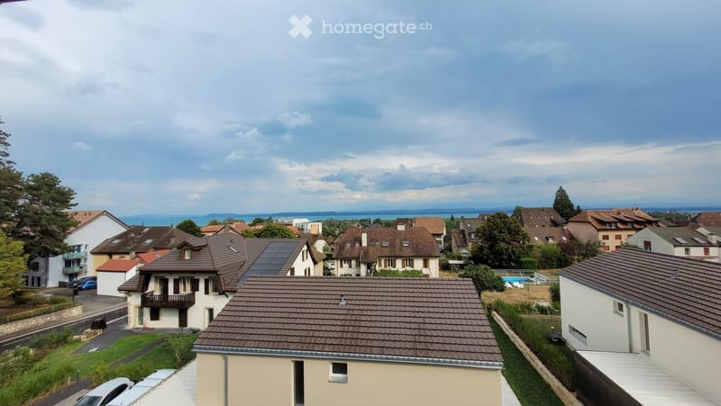 Residential neighborhood with multiple houses, solar panels on roofs, and a swimming pool in the background.