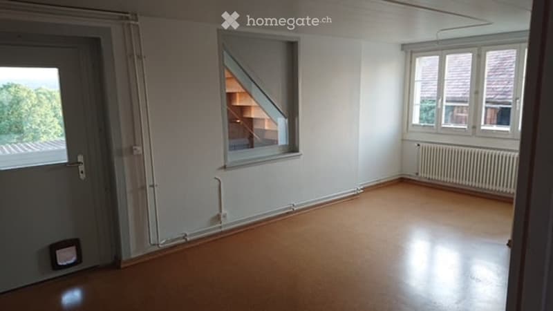 Empty room with wooden flooring, white walls, and large windows. No furniture or equipment present.
