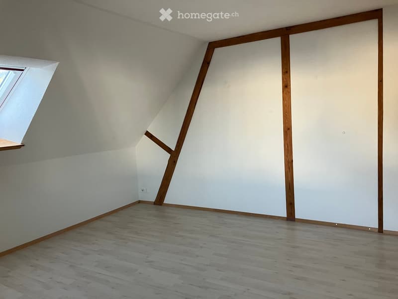 Empty room with wooden flooring, white walls, and a skylight window. No furniture or equipment present.