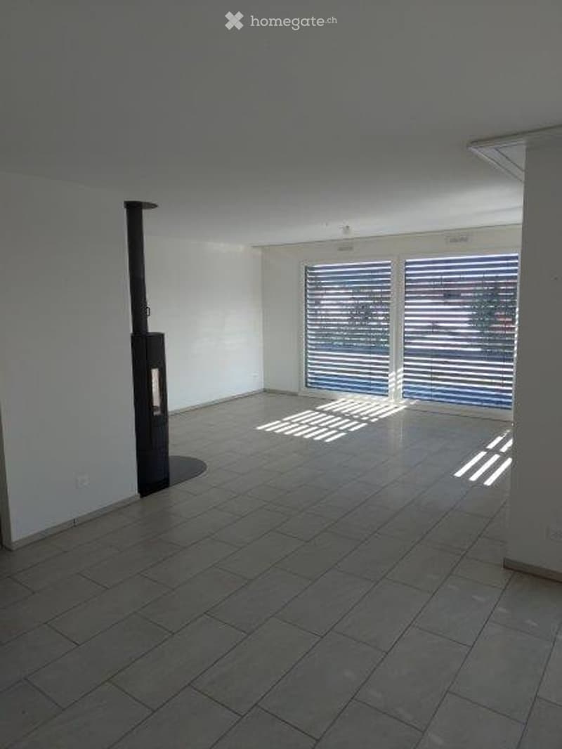 Empty room with tiled floor, white walls, large window with blinds, and a black column near the wall.