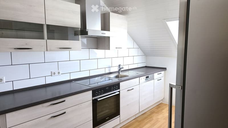 Modern kitchen with white cabinets, stainless steel appliances, and a sleek countertop.