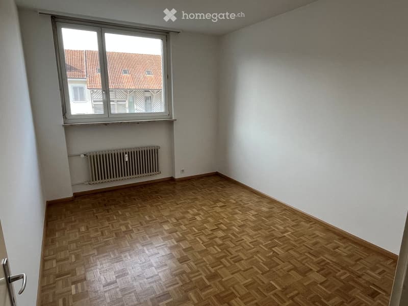 large room, parquet flooring, window, radiator, white walls