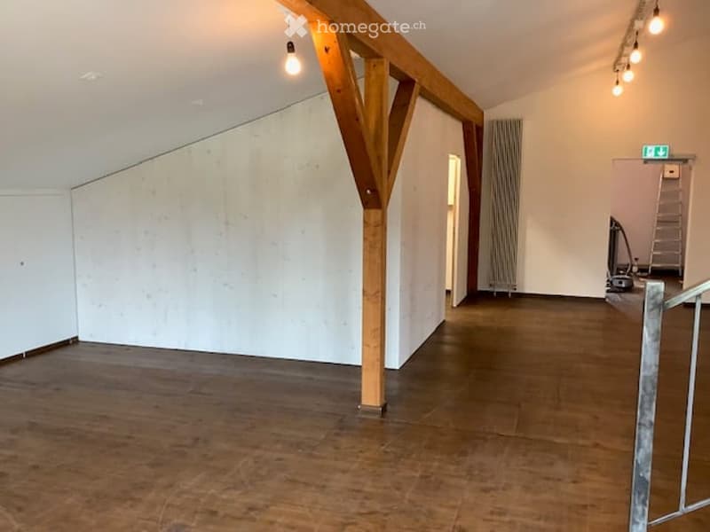 wooden pillars, wooden flooring, white walls, white ceiling, hanging lights, ladder, metal railing