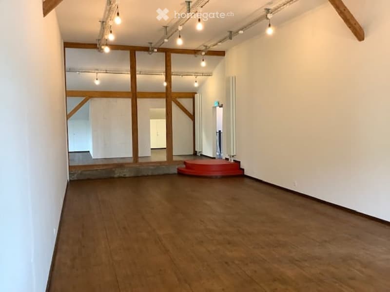 empty space with wooden floor and truss system on the ceiling