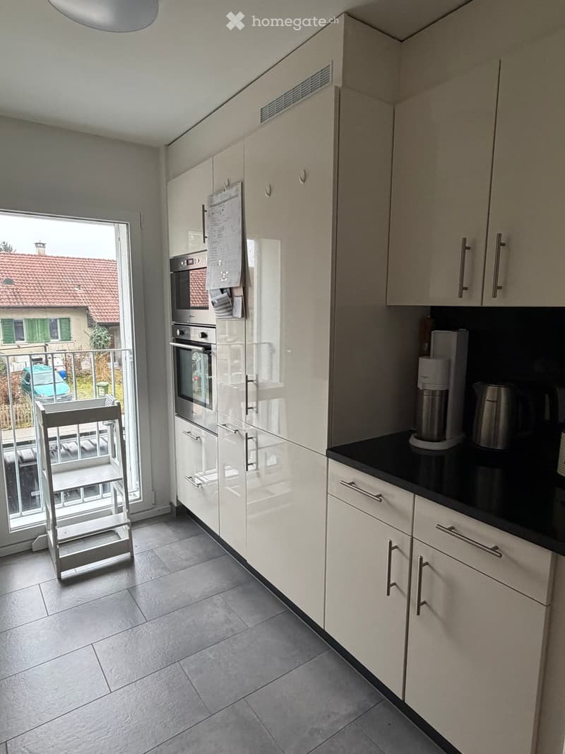 open kitchen, white cupboards, black countertops, modern appliances, floor-to-ceiling windows with access to balcony