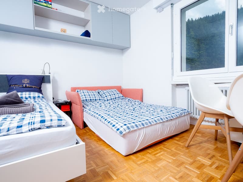 Room: 2 beds, window, bed sheet, pillows, nightstand, shelf, radiator, chair
