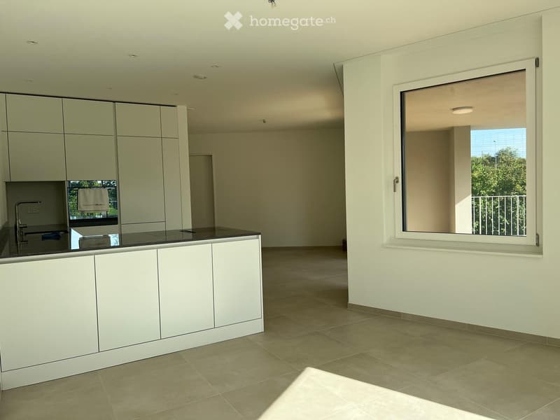 Modern kitchen with white cabinets, a black countertop, and a large window overlooking a balcony.
