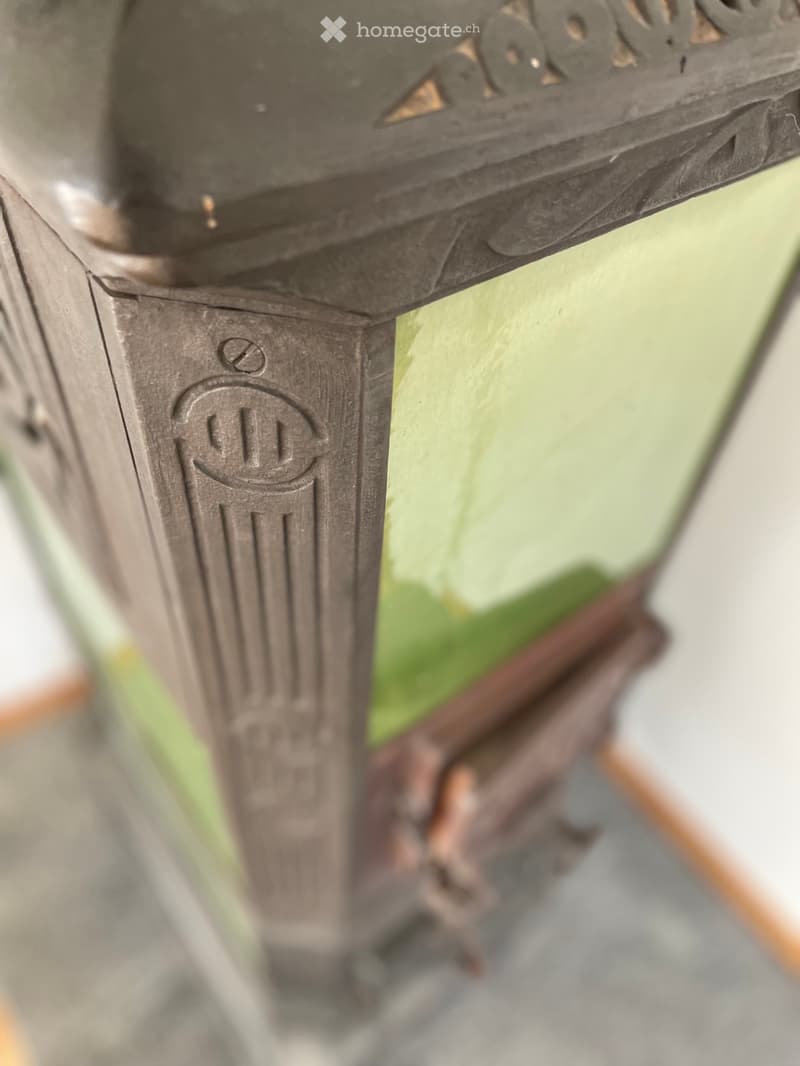 A close-up of a decorative metal lantern with intricate patterns and a glass top, placed on a wooden surface.