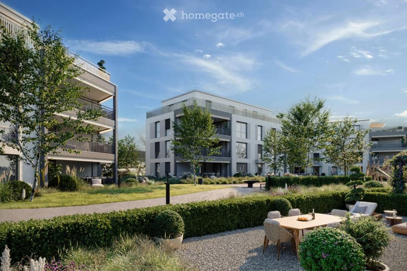 A modern residential complex with well-maintained gardens, outdoor seating areas, and contemporary buildings.