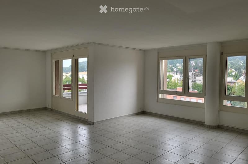 Empty room with tiled floor, large windows, and a sliding glass door leading to a balcony.