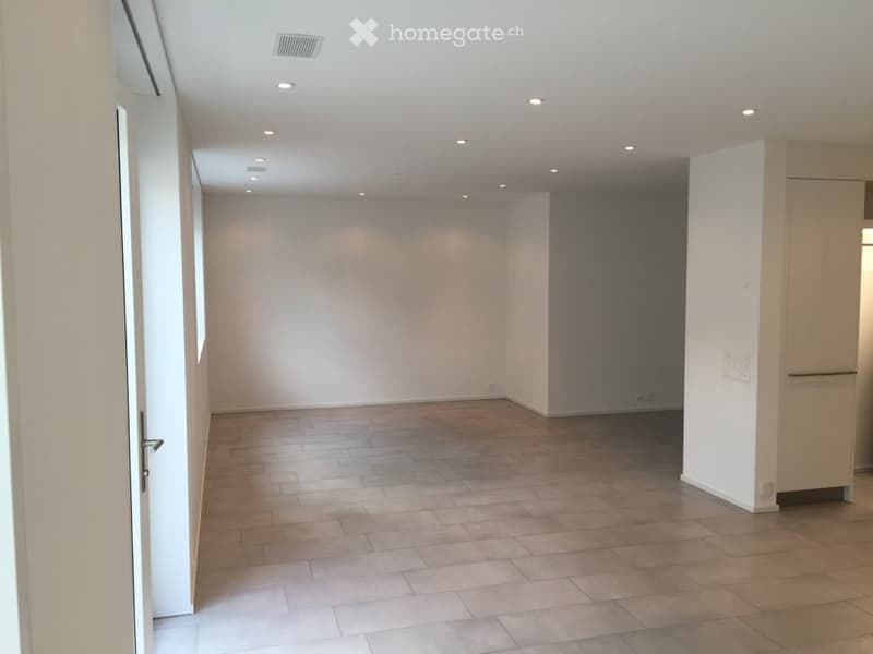 Empty room with wooden flooring, white walls, and recessed lighting. No furniture or equipment present.