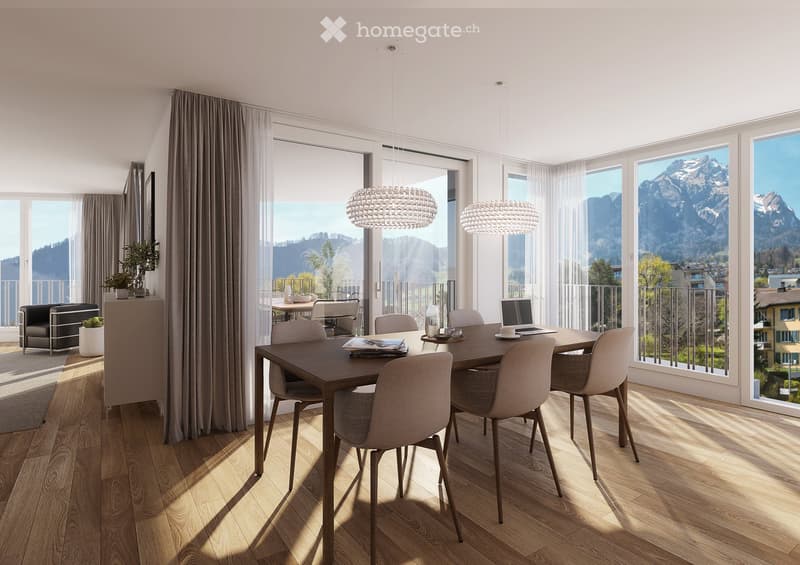 Modern dining room with wooden floor, large windows offering mountain views, dining table with chairs, laptop, cup, sofa, flower pot, and chandelier.