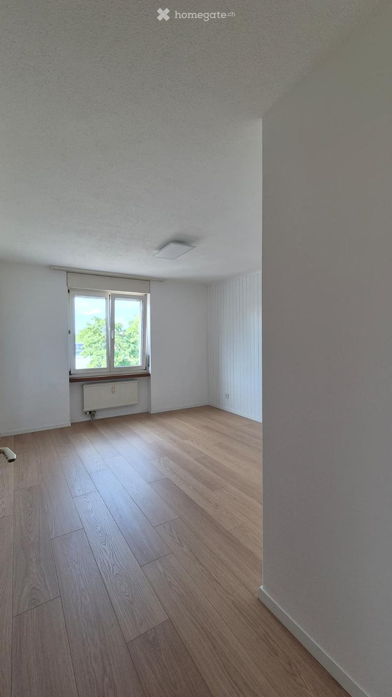 Empty room with wooden flooring, white walls, and a window with a radiator below it. No furniture or equipment is present.