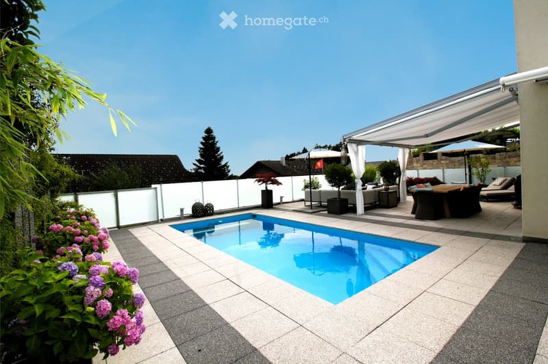 Modern outdoor area with a swimming pool, patio furniture, and a covered seating area with a pergola.