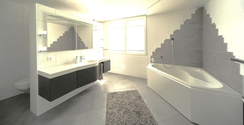 Modern bathroom with a large bathtub, double sink, mirror, and modern cabinetry.