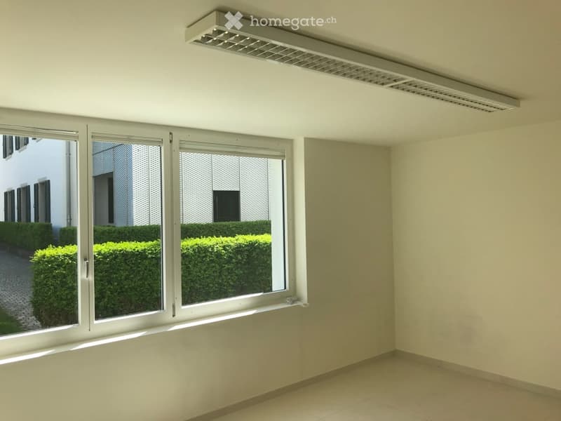 Empty room with large windows, white walls, and tiled floor. No furniture or equipment present.