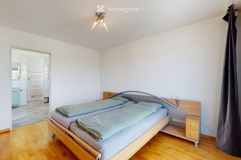 Cozy bedroom with two single beds, wooden nightstand, and modern lighting fixture.
