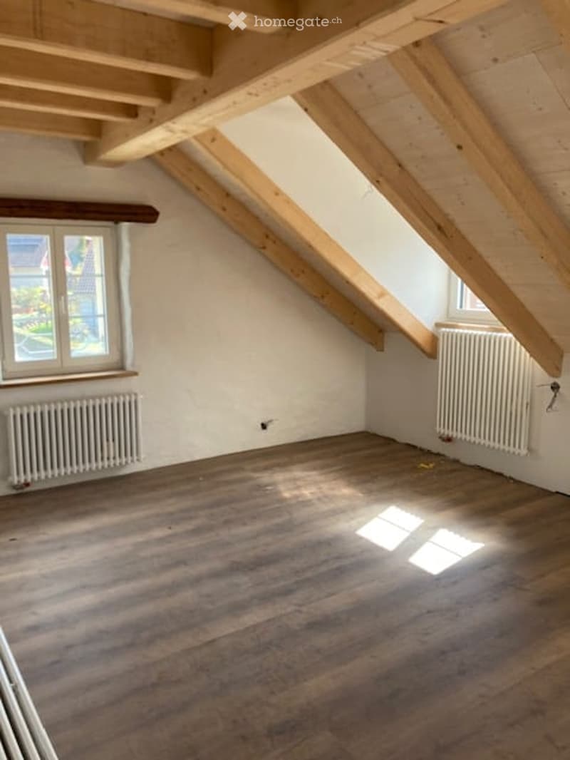 empty room, wooden floor, wooden beams, white walls, two windows, two radiators