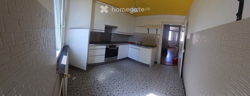 Modern kitchen with white cabinets, stainless steel appliances, and a mosaic tile floor. The space features a refrigerator, oven, sink, and faucet, with a window providing natural light.
