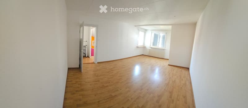 Empty room with wooden flooring, white walls, and large windows. No furniture or equipment present.