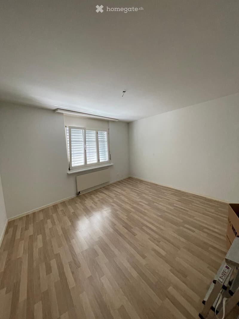 Empty room with wooden flooring, white walls, and a window with blinds. No furniture or equipment is present.