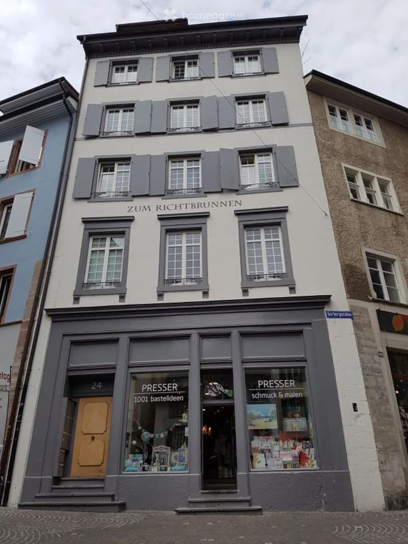 3 story house, gray shutters, white walls, ground floor windows, signage