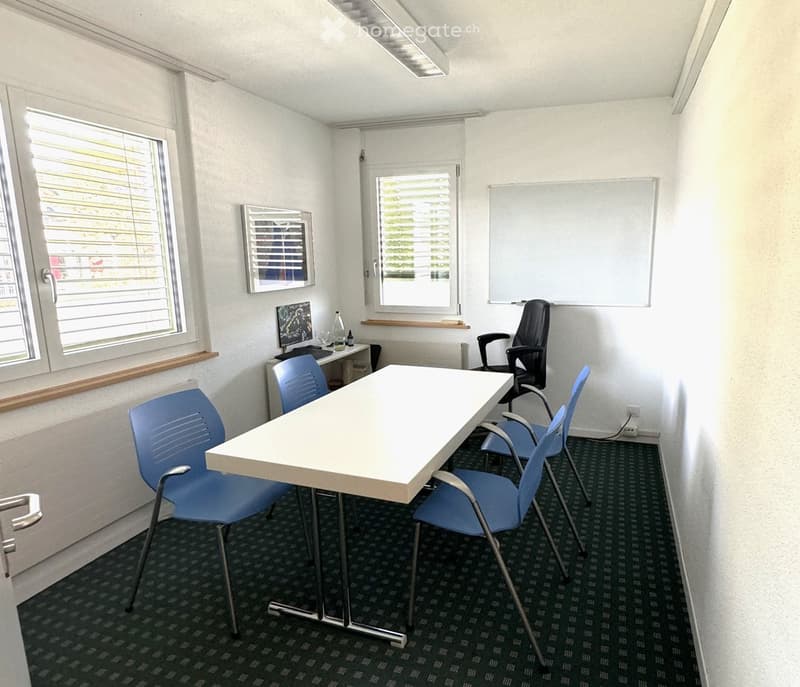 empty room with white table, blue chairs, white walls, windows, whiteboard, radiator, desk with computer