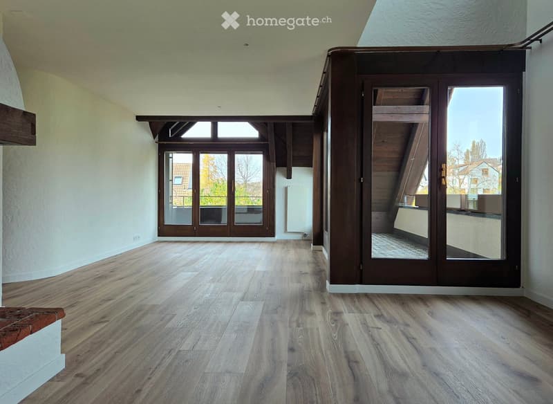 Empty room with wooden flooring, large windows, and a staircase leading to an upper level. No furniture or equipment visible.
