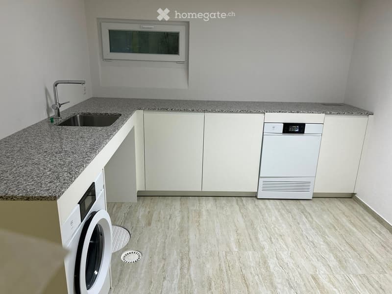 Modern kitchen with white cabinets, granite countertop, stainless steel sink, and built-in appliances including a dishwasher and microwave.