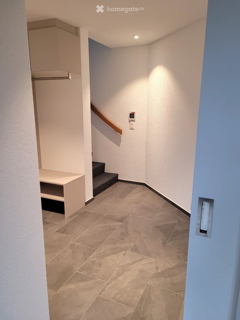 white walls, tiled floor, stairs, entrance to another room