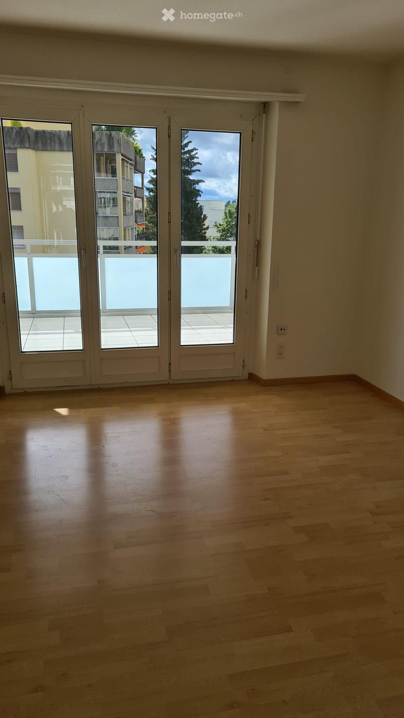 wooden floor, sliding doors to balcony, balcony railing, window, power outlet, neutral walls