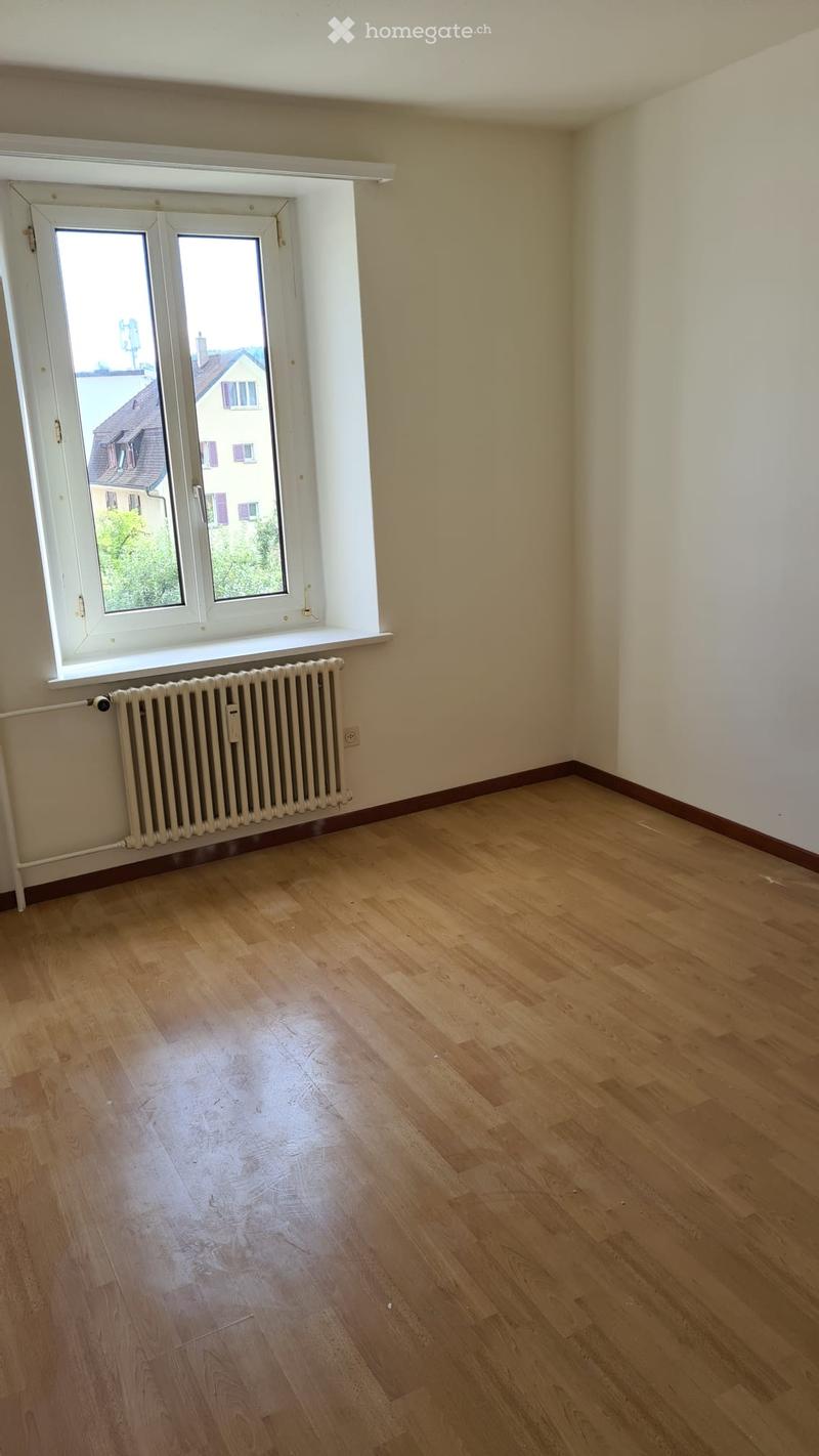 large room, white walls, wooden floor, large window, radiator
