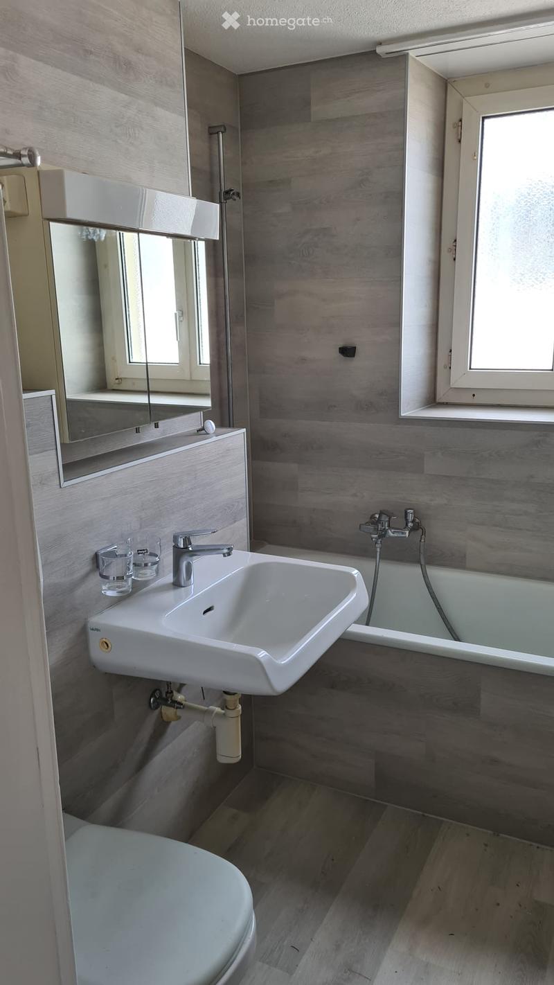 Bathroom with bathtub, sink, toilet, wooden flooring, glass door, mirror and window
