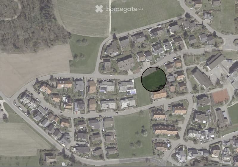 Suburban neighborhood with single family homes, some with solar panels, a playground, and roads.