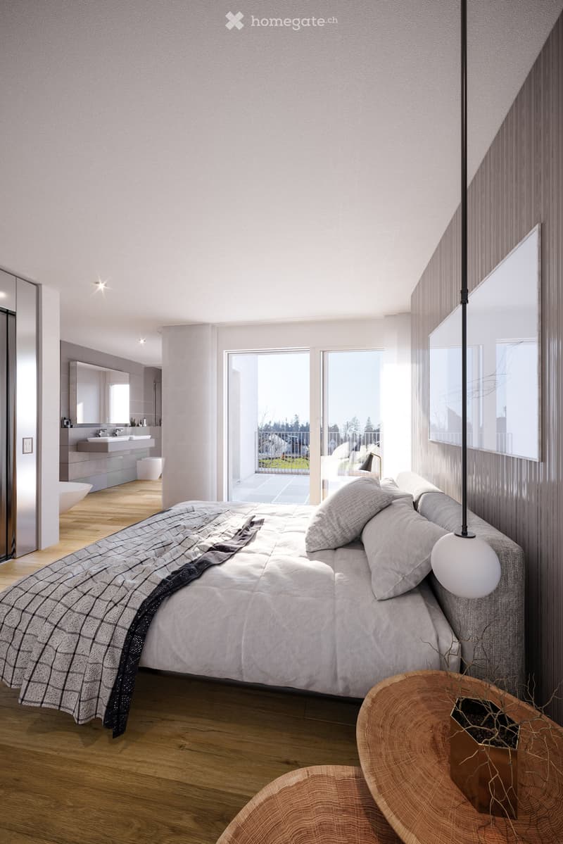 Modern bedroom with a large bed, wooden floor, large windows, and a view of a balcony. Includes a side table, lamp, and a small seating area.