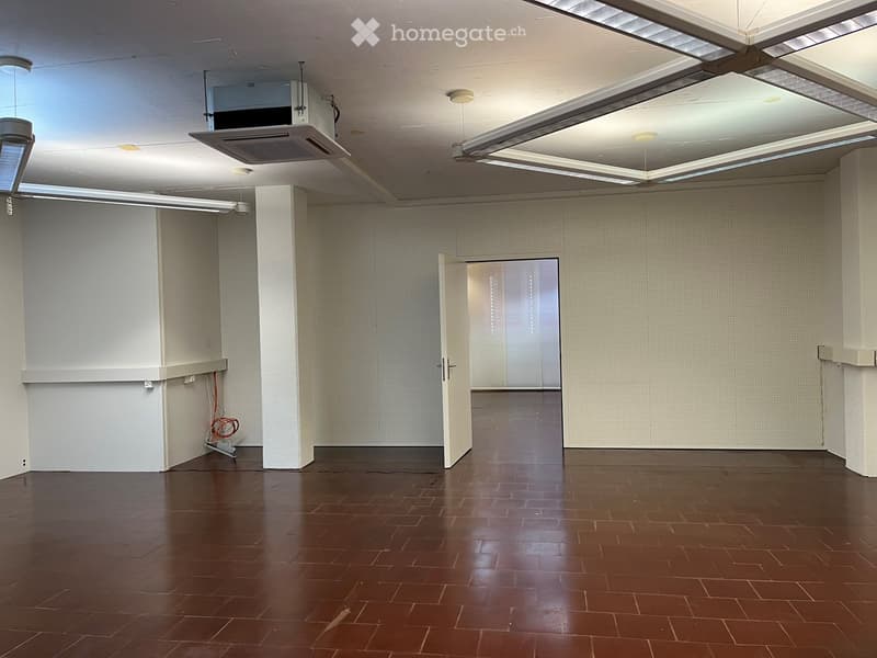empty room, white walls, brown tiled floor, open door, ceiling lights
