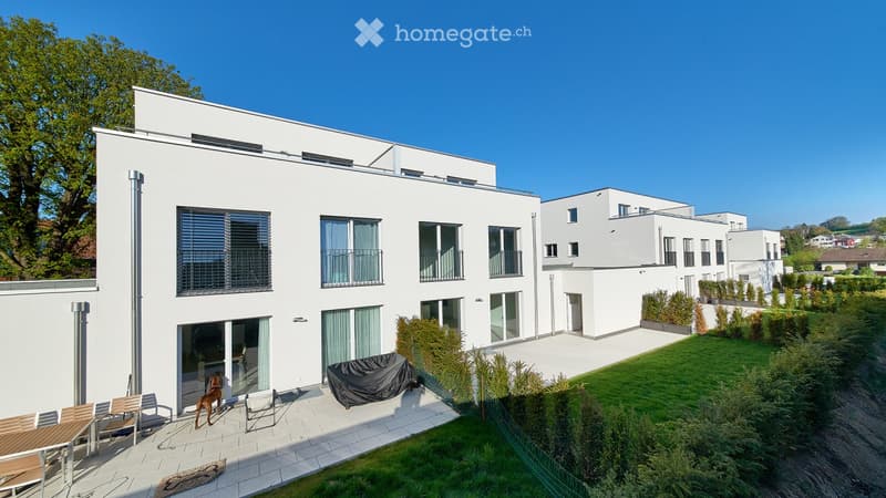 White modern townhouse, with glass balcony, garden, patio, large windows