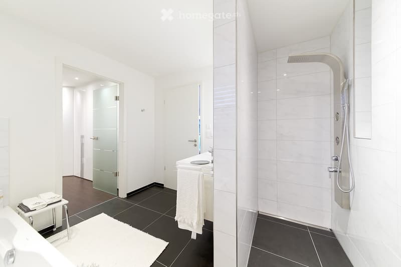 modern and clean bathroom, white tiles, bathtub, shower, sink, towels