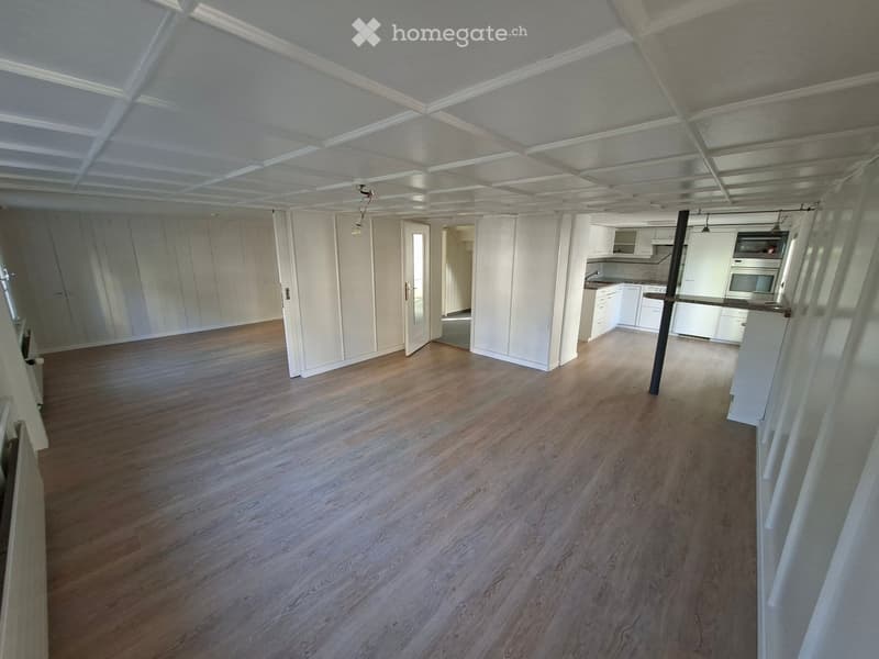 Empty room with wooden flooring, white walls, and white cabinetry visible in the background. No furniture or personal items are present.