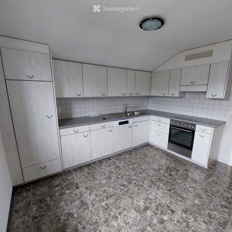 Modern kitchen with white cabinets, granite countertop, sink, faucet, and built-in oven. The space is clean and organized with tiled backsplash and granite flooring.