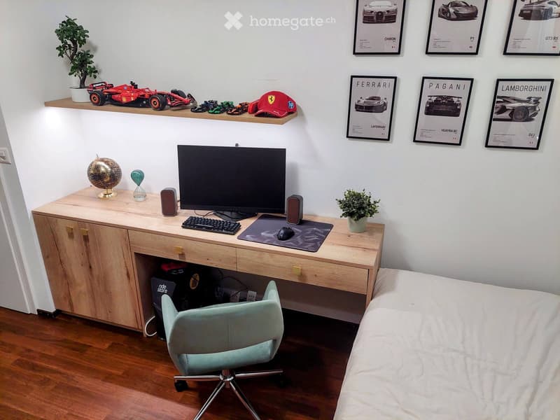 A modern, well-furnished room with a desk setup, a bed, and decorative items including posters, a globe, and a plant. The desk features a screen, keyboard, mouse, and speakers, while the room includes a comfortable chair and a neatly made bed.