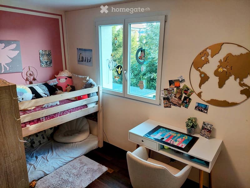 Cozy children's bedroom with bunk bed, desk, chair, and world map on wall. Features a large window with view of greenery.
